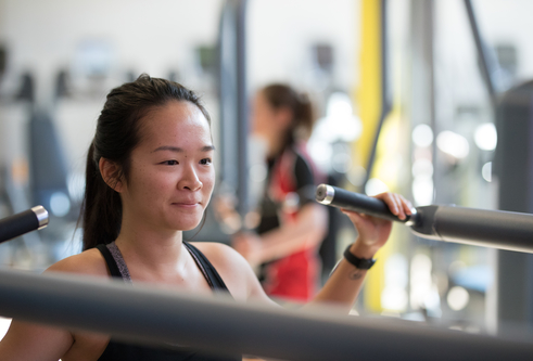 Girl using one of the machines in the gym.