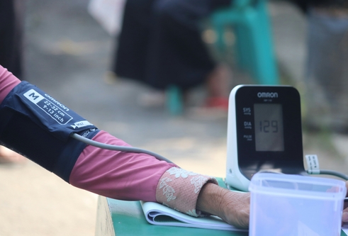 A woman's arm wrapped in blood pressure monitor