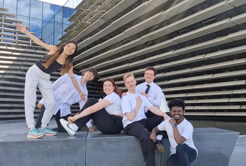 A group of six students on a bench outside of the V&A museum in Dundee.