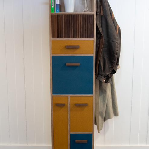 Low angle image of final cabinet, showing the detail of the legs and coloured drawer fronts.