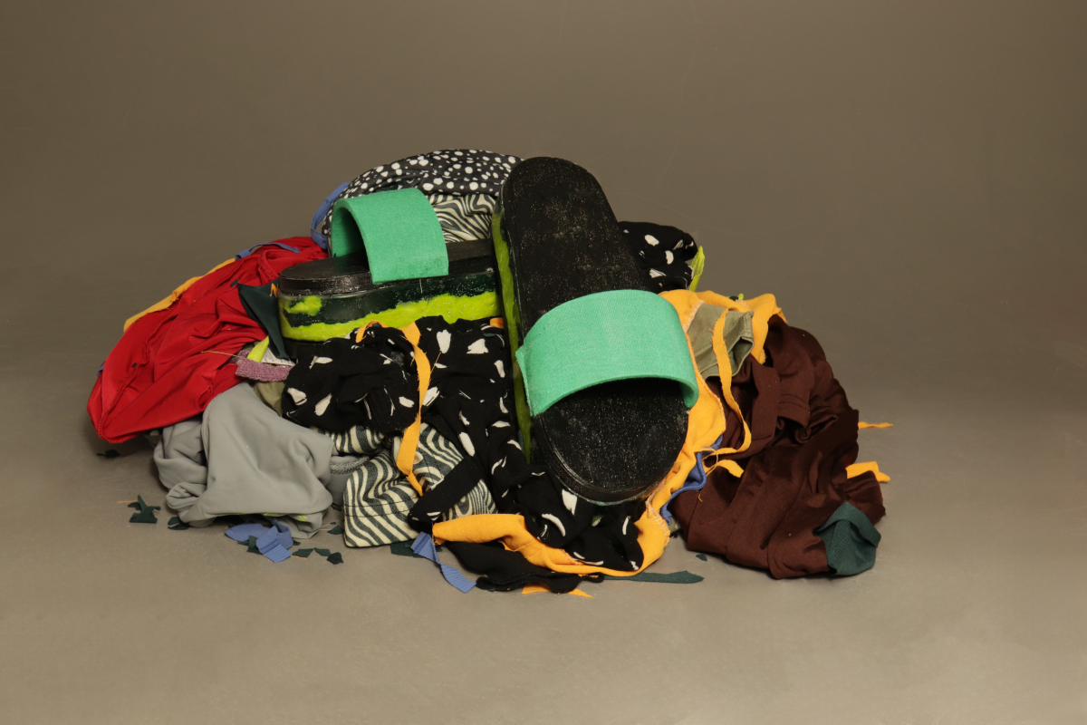 Messy pile of different colours of clothing. Black and green sliders positioned in the centre.