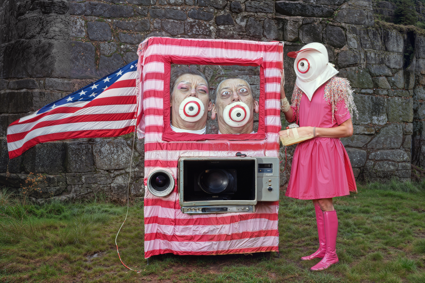 striped box with heads with targets on them inside, next to person standing in pink clothes